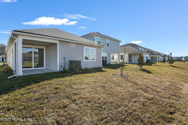 rear view of property with central AC unit, a yard, and a patio area