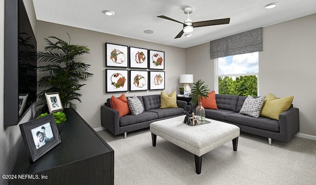 living room featuring a textured ceiling, ceiling fan, and light carpet