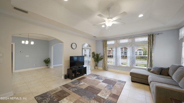 tiled living room with a raised ceiling, ceiling fan with notable chandelier, and ornamental molding