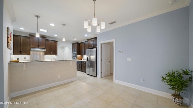 kitchen with light stone countertops, hanging light fixtures, a breakfast bar area, dark brown cabinets, and appliances with stainless steel finishes