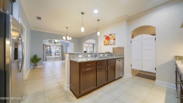 kitchen featuring sink, light stone countertops, ornamental molding, decorative light fixtures, and stainless steel appliances