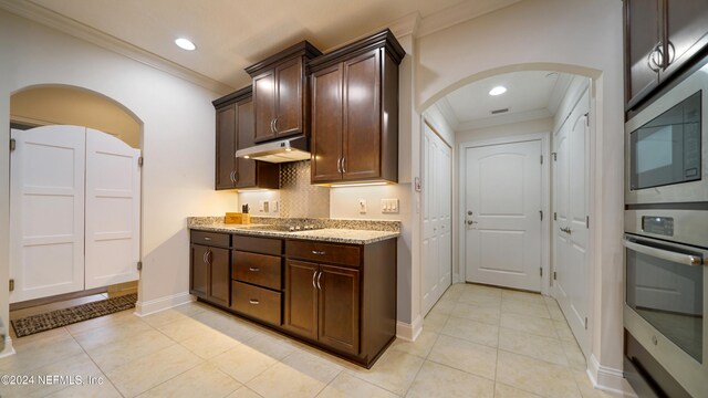 kitchen featuring dark brown cabinets, light stone countertops, ornamental molding, and light tile patterned floors