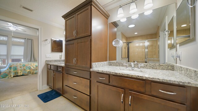 bathroom featuring an enclosed shower, ornamental molding, vanity, ceiling fan, and tile patterned flooring