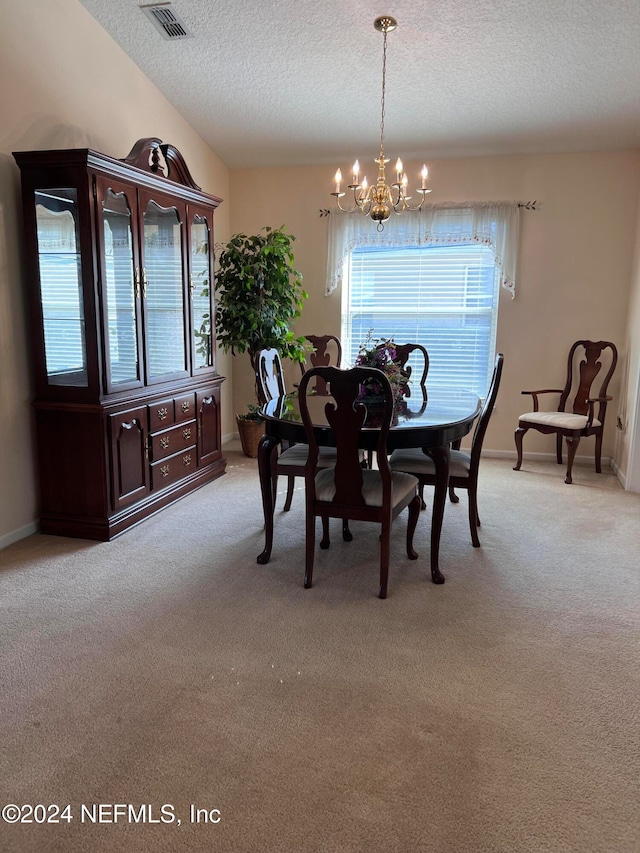 carpeted dining room with a textured ceiling and a notable chandelier