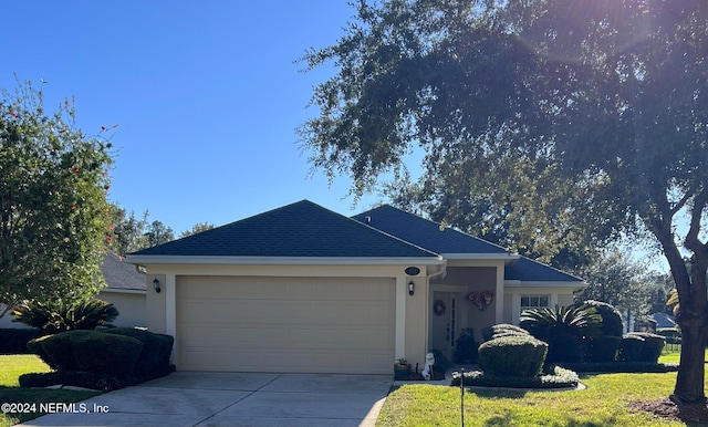 single story home featuring a garage and a front yard