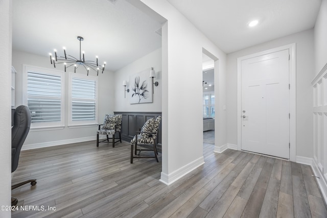 entryway with wood-type flooring and a notable chandelier