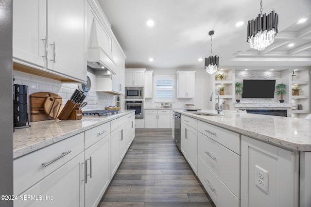 kitchen featuring sink, white cabinets, hanging light fixtures, and appliances with stainless steel finishes