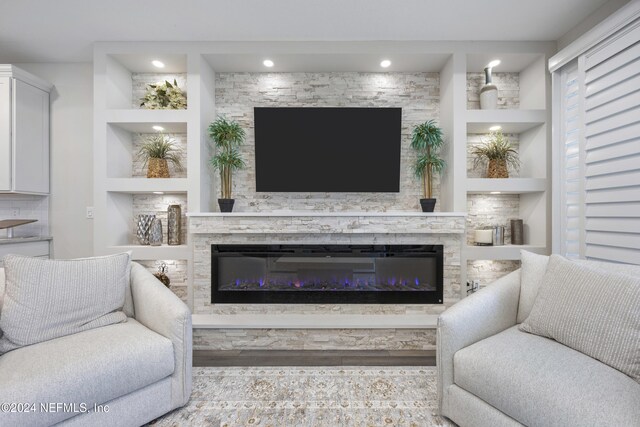 94 Hickory Pine Dr, Saint Augustine, FL 32092 - living room featuring built in shelves, a glass covered fireplace, and wood finished floors