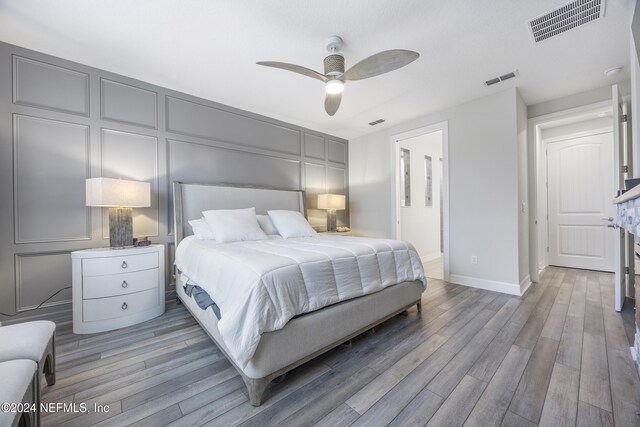 94 Hickory Pine Dr, Saint Augustine, FL 32092 - bedroom featuring light wood-type flooring, baseboards, ceiling fan, and a decorative wall