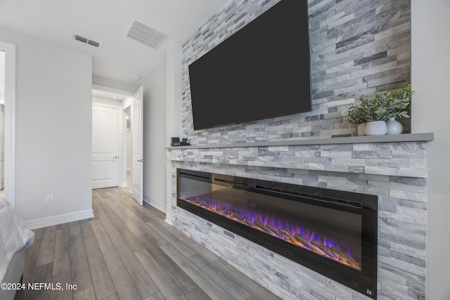 details featuring hardwood / wood-style flooring and a stone fireplace