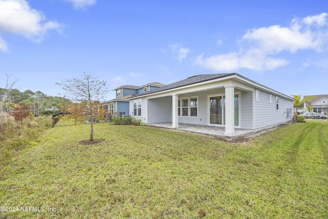 rear view of property with a lawn and a patio area