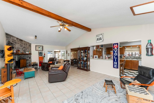 living room featuring beamed ceiling, ceiling fan, light tile patterned flooring, and a textured ceiling