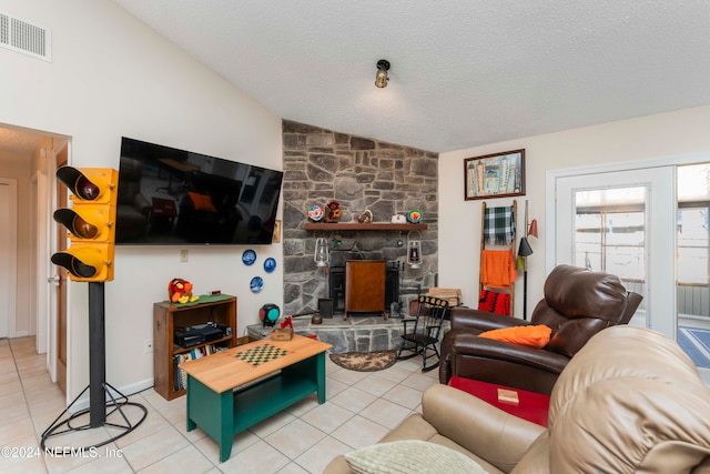 living room featuring a textured ceiling, a wood stove, tile patterned flooring, and lofted ceiling