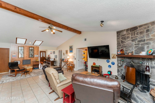 living room featuring a textured ceiling, ceiling fan, light tile patterned floors, lofted ceiling with beams, and a fireplace