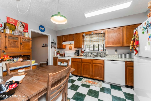 kitchen featuring a textured ceiling, sink, and white appliances