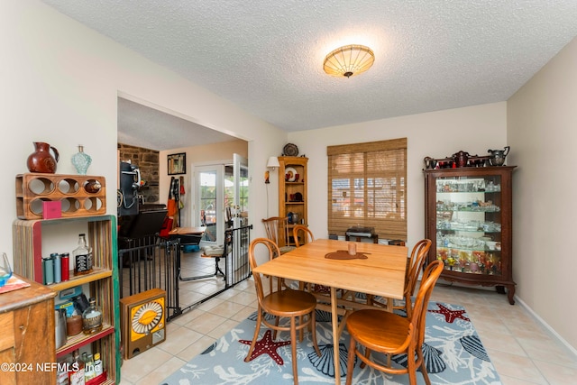 dining area featuring a textured ceiling, a wealth of natural light, and light tile patterned flooring