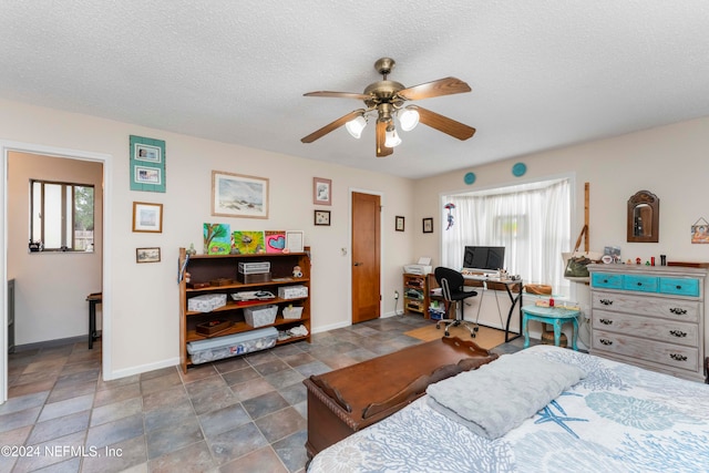 bedroom with multiple windows, ceiling fan, and a textured ceiling