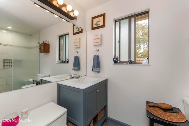 bathroom featuring tiled shower, vanity, and toilet