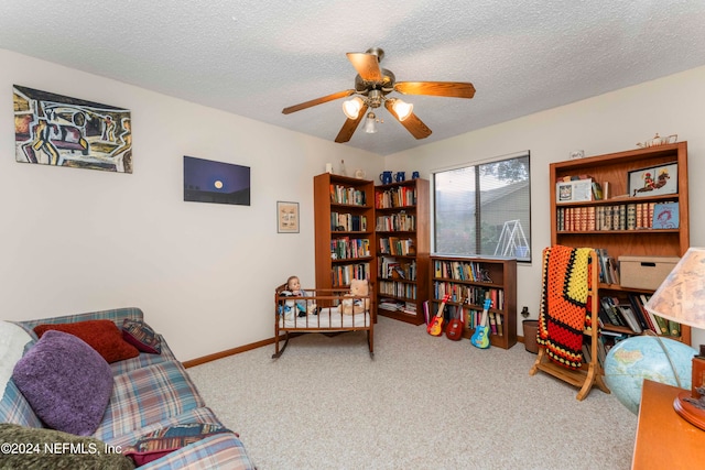 sitting room featuring carpet, a textured ceiling, and ceiling fan