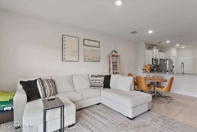 living room featuring light tile patterned floors and sink