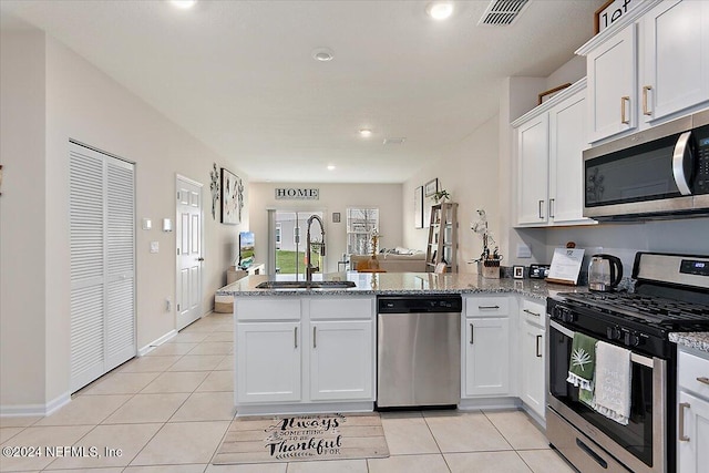 108 Coastline Way, Saint Augustine, FL 32092 - kitchen with appliances with stainless steel finishes, a sink, a peninsula, light tile patterned floors, and recessed lighting