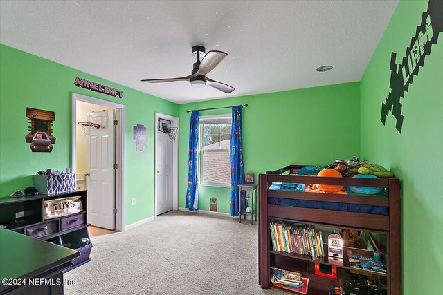 bedroom featuring ceiling fan, light colored carpet, and a textured ceiling