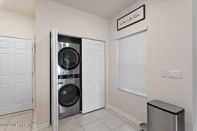 108 Coastline Way, Saint Augustine, FL 32092 - washroom with stacked washer / dryer, light tile patterned floors, and baseboards