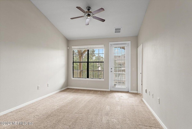 carpeted empty room featuring ceiling fan and vaulted ceiling