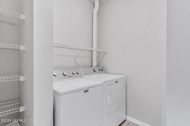 clothes washing area with separate washer and dryer