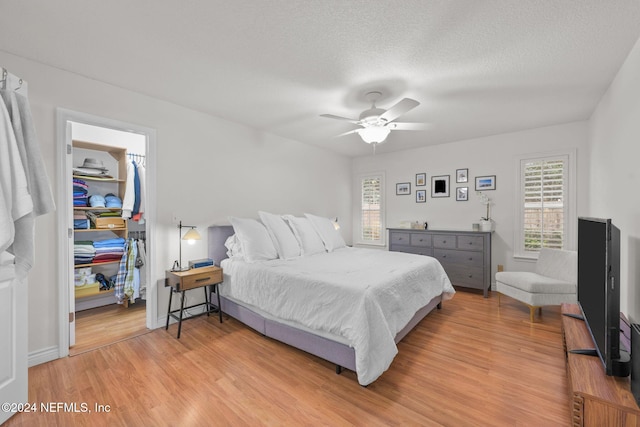 bedroom featuring a textured ceiling, light hardwood / wood-style floors, and ceiling fan