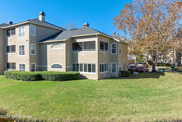 rear view of property featuring a yard