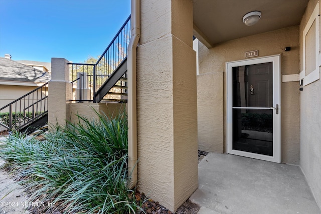 1701 The Greens Way Unit 311, Jacksonville Beach, FL 32250 - doorway to property featuring stucco siding