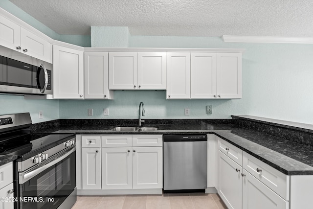 1701 The Greens Way Unit 311, Jacksonville Beach, FL 32250 - kitchen featuring stainless steel appliances, a textured ceiling, white cabinetry, a peninsula, and dark stone countertops