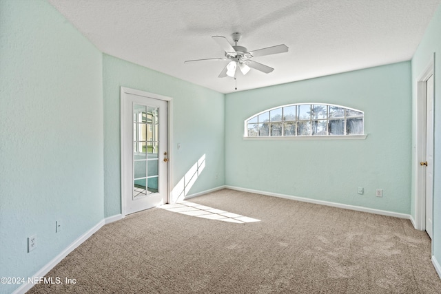 spare room featuring carpet flooring, ceiling fan, and a textured ceiling