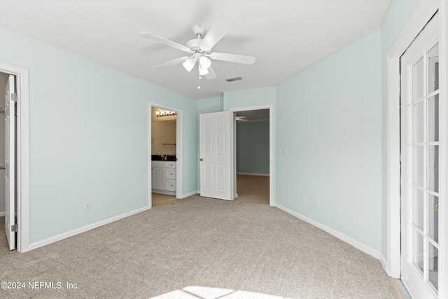 1701 The Greens Way Unit 311, Jacksonville Beach, FL 32250 - unfurnished bedroom featuring carpet, a spacious closet, ensuite bathroom, and a ceiling fan