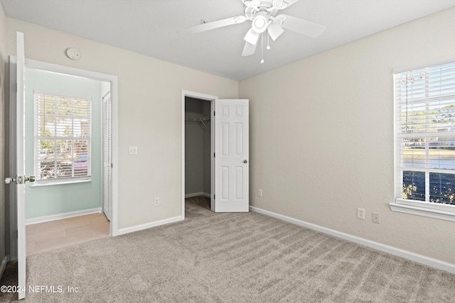 1701 The Greens Way Unit 311, Jacksonville Beach, FL 32250 - unfurnished bedroom featuring carpet floors, a spacious closet, a closet, and a ceiling fan