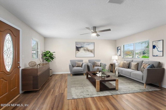 living room featuring hardwood / wood-style floors, a textured ceiling, plenty of natural light, and ceiling fan