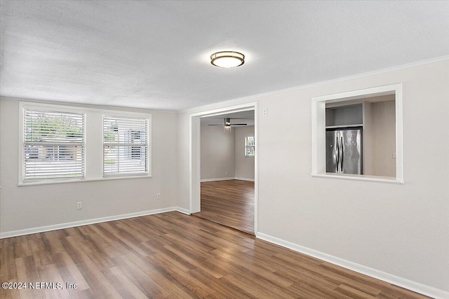 empty room featuring a textured ceiling, hardwood / wood-style flooring, and ceiling fan