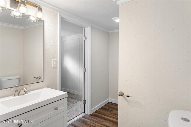 bathroom featuring hardwood / wood-style floors, vanity, toilet, and ornamental molding