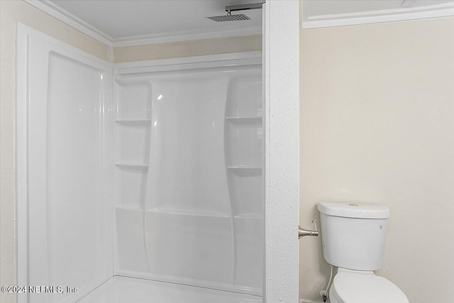 bathroom featuring toilet, a shower, and ornamental molding