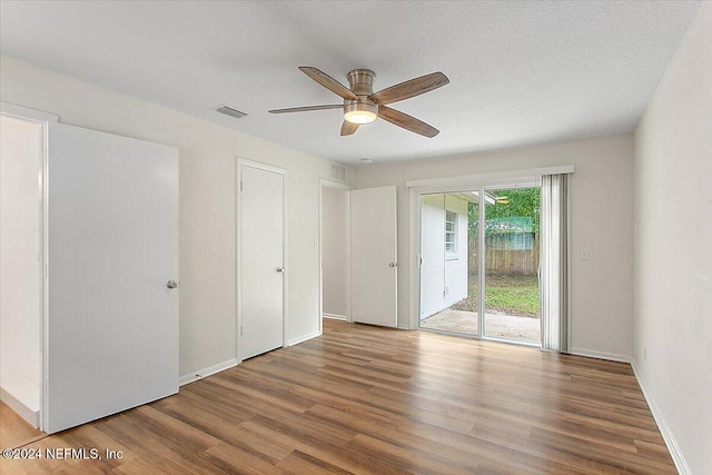 unfurnished room featuring hardwood / wood-style flooring, ceiling fan, and a textured ceiling