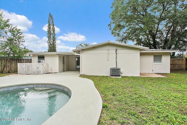 back of property featuring a fenced in pool, a lawn, a patio, and central AC unit