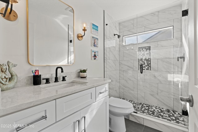 bathroom featuring tile patterned floors, vanity, toilet, and a shower with shower door