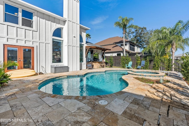 view of pool with an in ground hot tub, french doors, and a patio