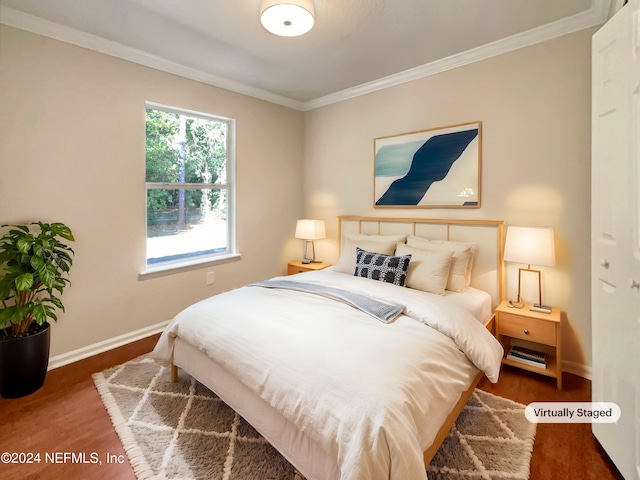 bedroom with ornamental molding and dark wood-type flooring