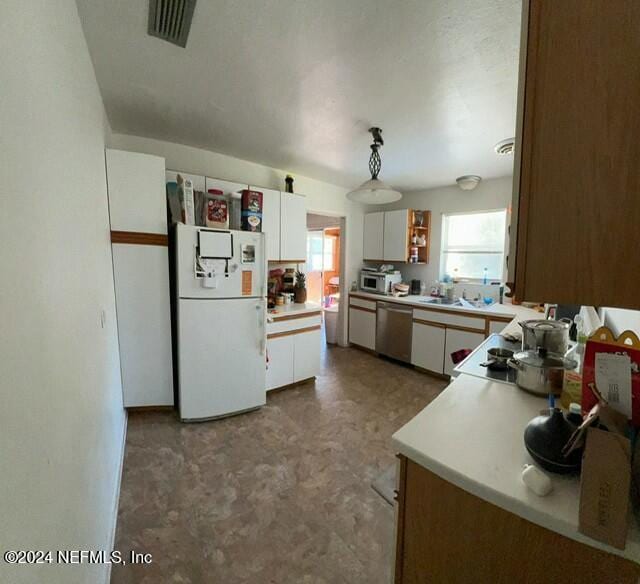 kitchen featuring white cabinets, decorative light fixtures, white appliances, and sink