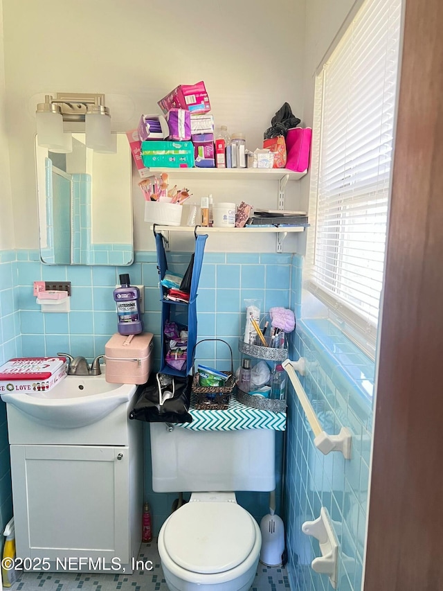 bathroom featuring vanity, tile walls, and toilet