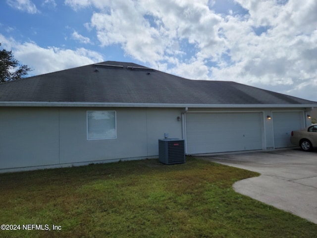 view of property exterior with a garage, central air condition unit, and a yard