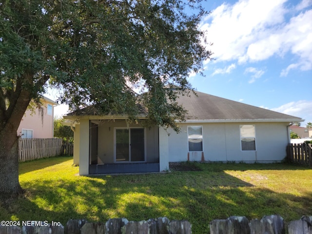 rear view of property with a yard