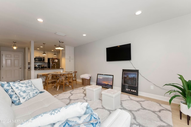 living room with light hardwood / wood-style flooring and sink